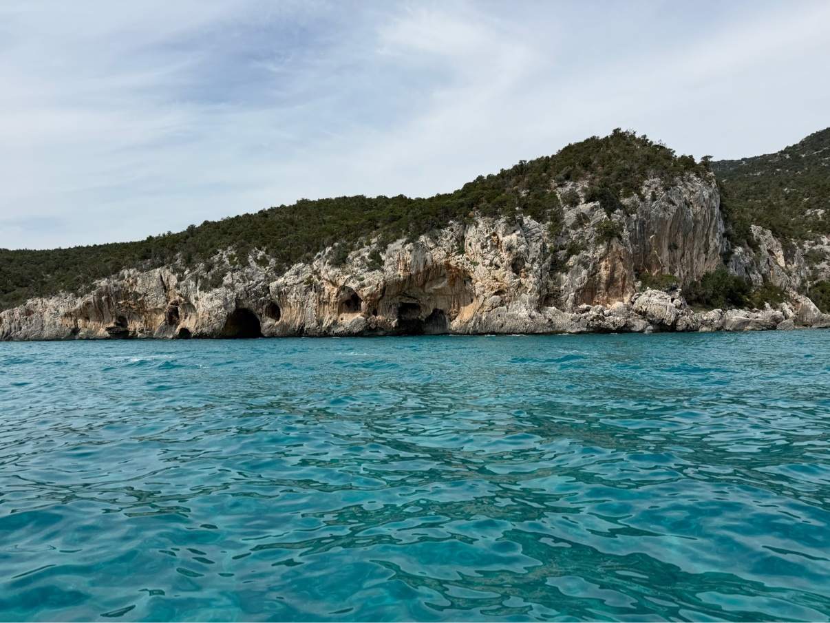 Sea caves in the cliffs along the Sardinian coast, seen from a boat
